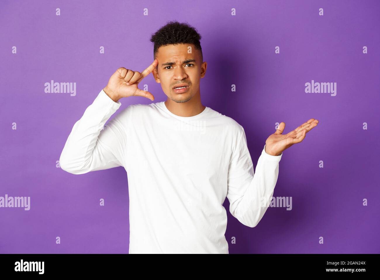 Image of angry african-american man, looking confused, pointing at head ...