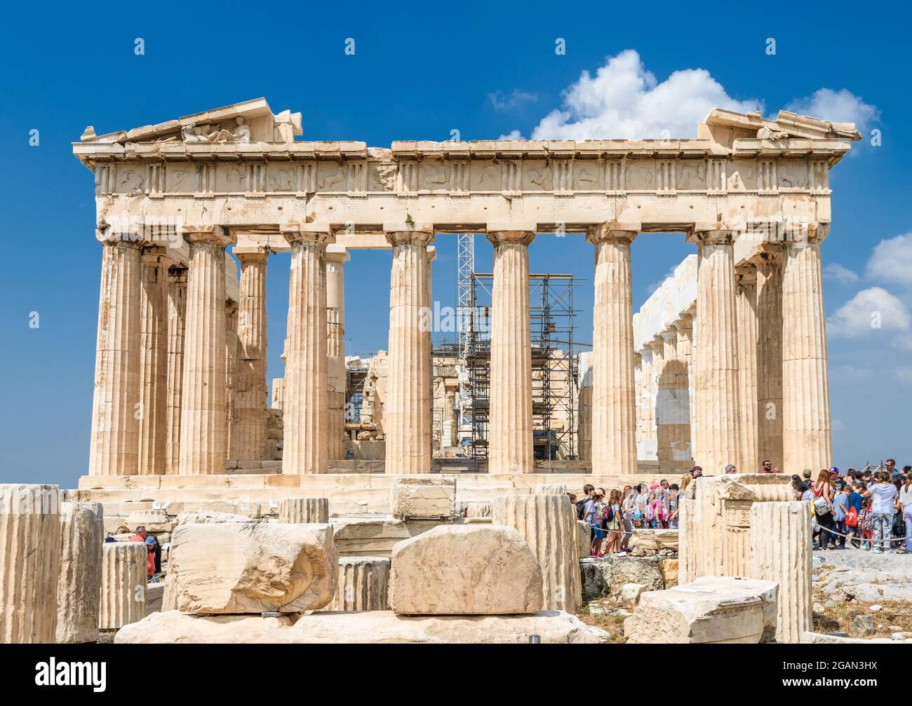People visit Parthenon on Acropolis on sunny day, Athens, Greece. It is top tourist attraction of Athens. Ancient Greek ruins on Stock Photo