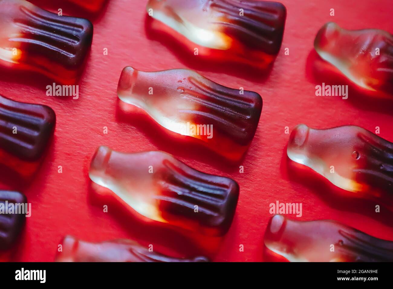 Macro cola gummy jelly candies pattern, bottle shaped sweets Stock