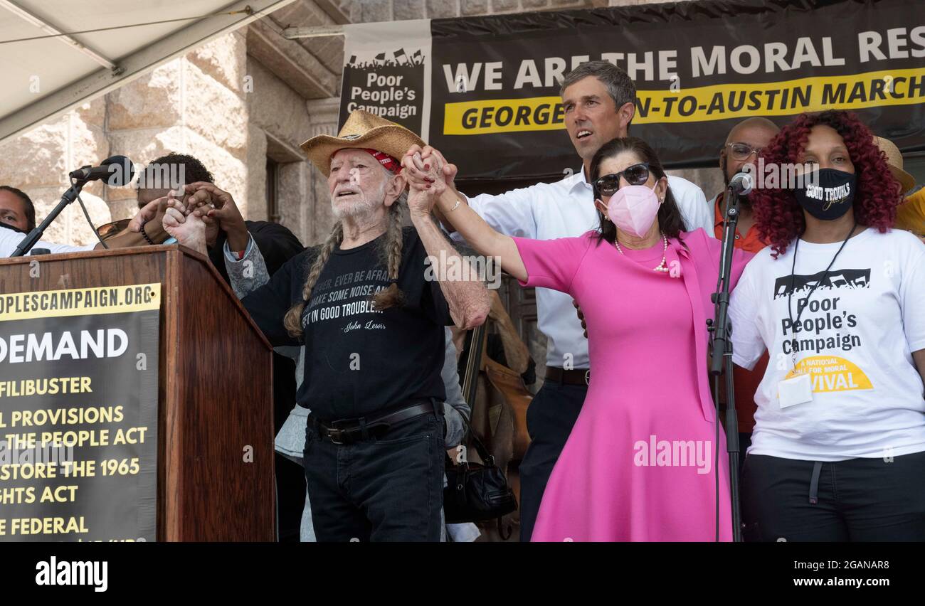 Austin, Texas USA, July 31, 2021: Left to right, singer Willie Nelson, former Texas congressman and activist Beto O'Rourke and Luci Johnson, daughter of U.S. Pres. Lyndon Johnson, hold hands as voting rights advocates attend a rally at the Texas Capitol, where dozens of speakers criticized Republican efforts to alter voting procedures nationwide and in Texas. About 3,000 people were treated to a 3-song set by Nelson and his band. Credit: Bob Daemmrich/Alamy Live News Stock Photo