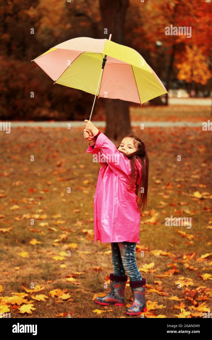 Beautiful little girl with umbrella in park Stock Photo - Alamy