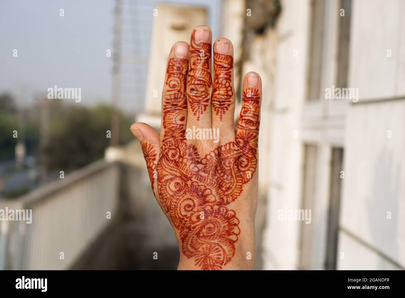 Raising henna painted hand in support of women empowerment. Stock Photo