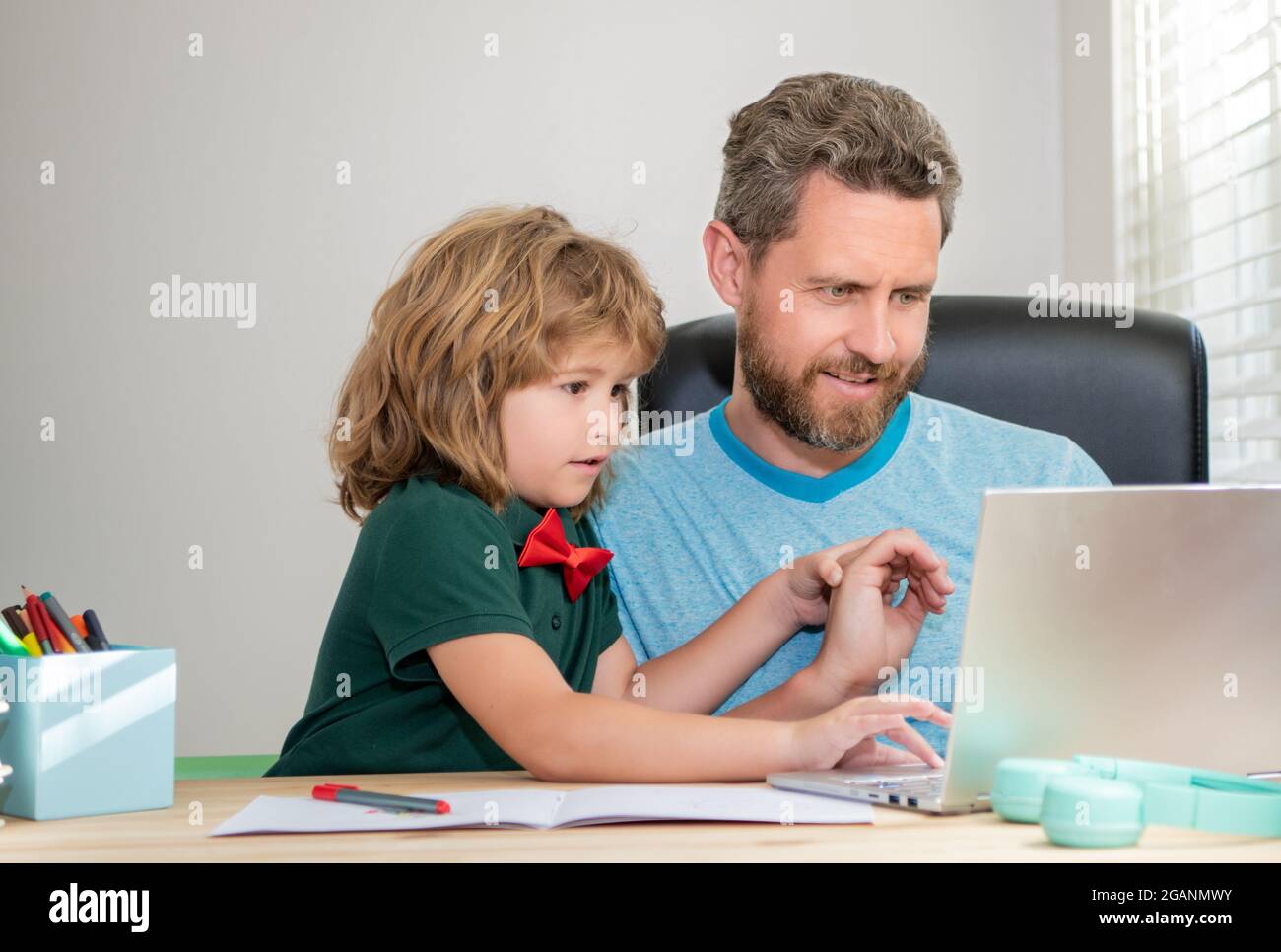 back to school. dad and son use computer at home. family and parenthood ...
