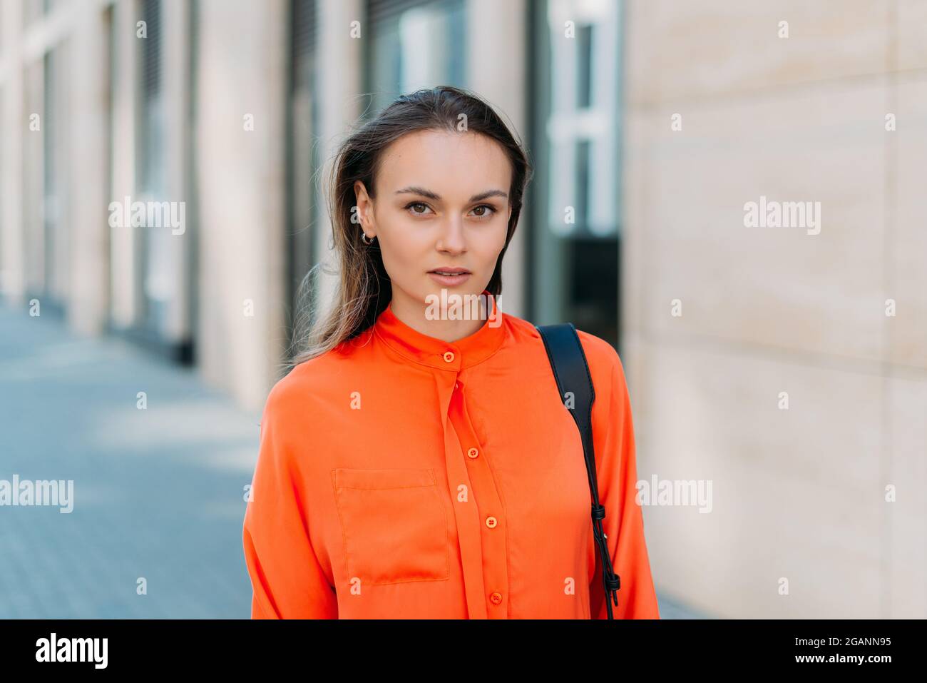 Caucasian girl looking at the camera and walking around the city. Stock Photo