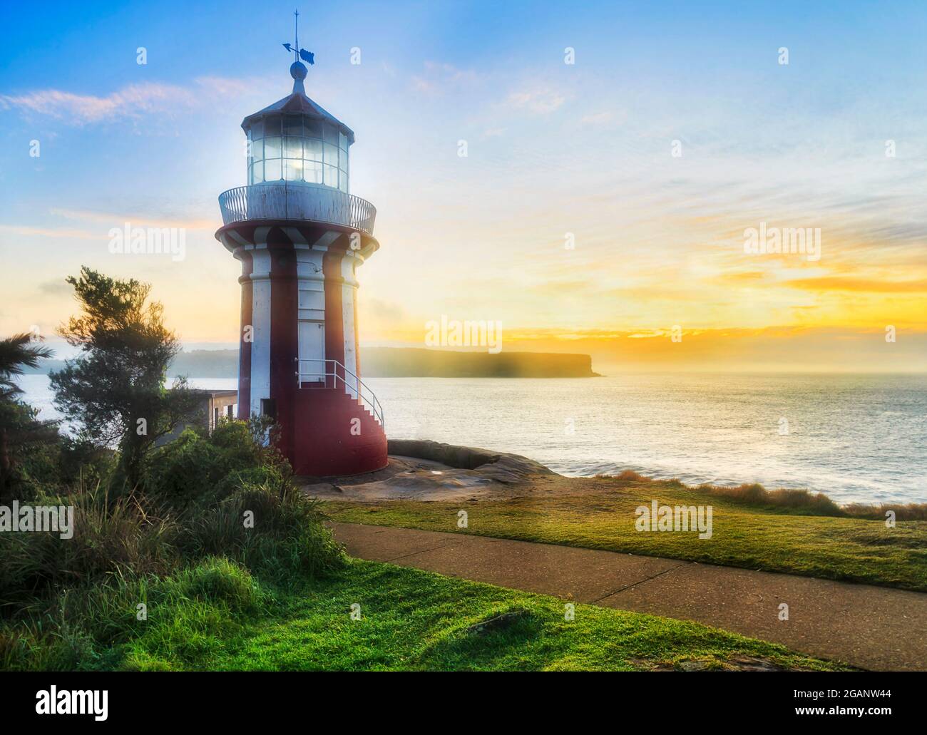 Historic red-white Hornby lighthouse on Sydney South head at the entrance to the Harbour - facing new day of the rising sun. Stock Photo