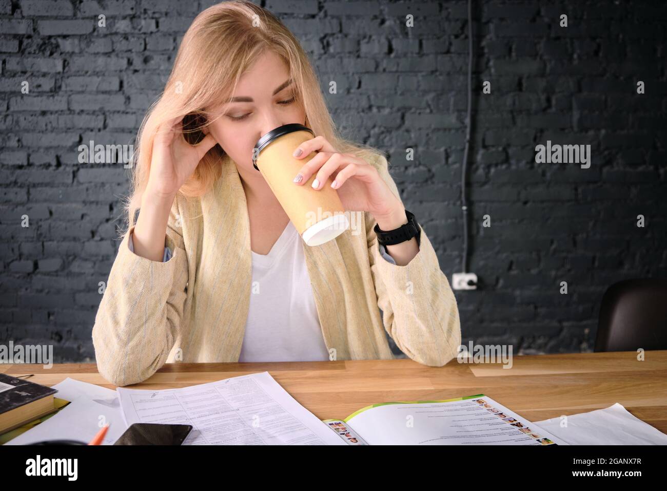 Woman reads documents drinking coffee Stock Photo