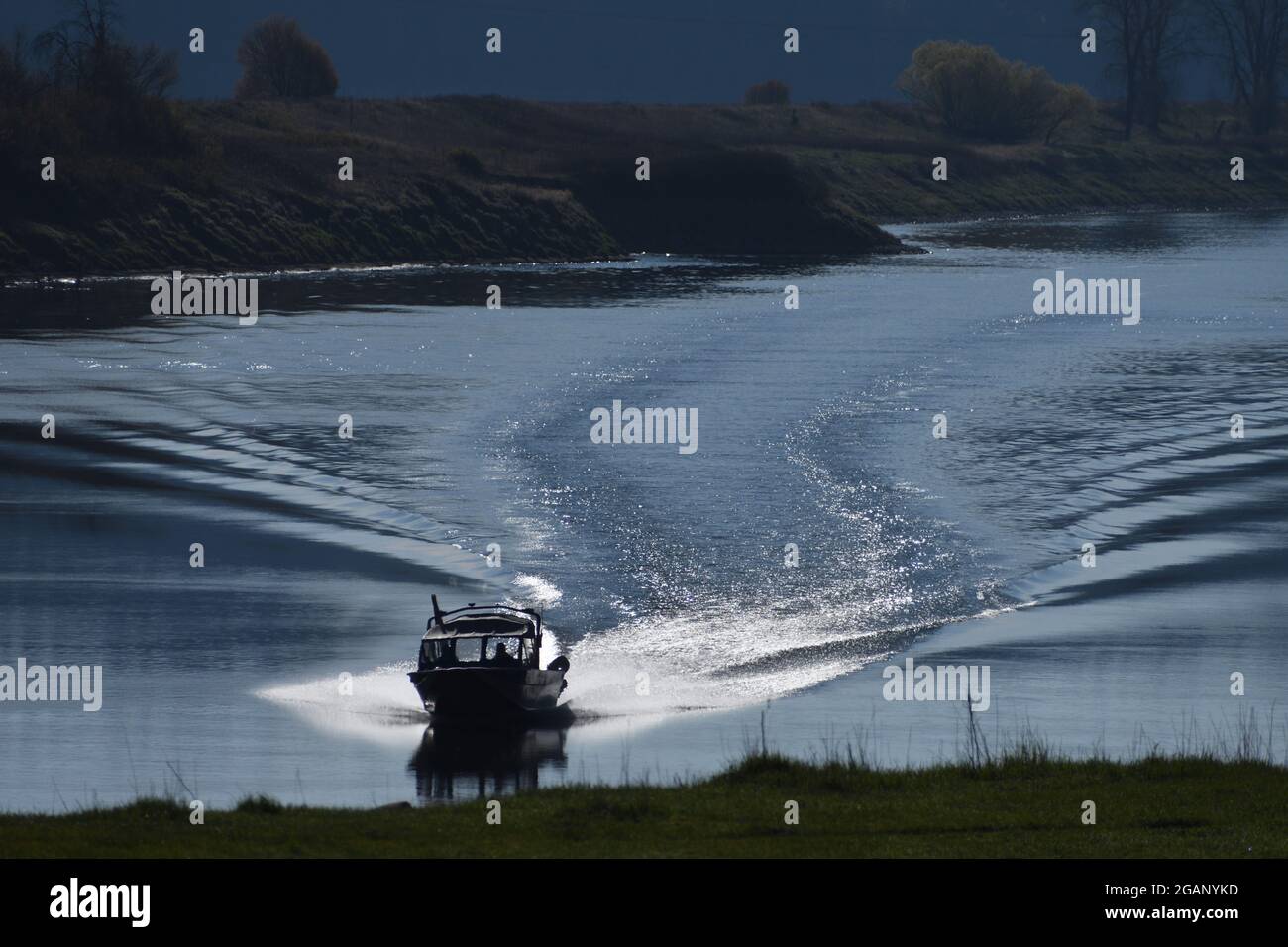Fishing boat leaving a wake on the Kootenai River in spring. Near Bonners Ferry, North Idaho