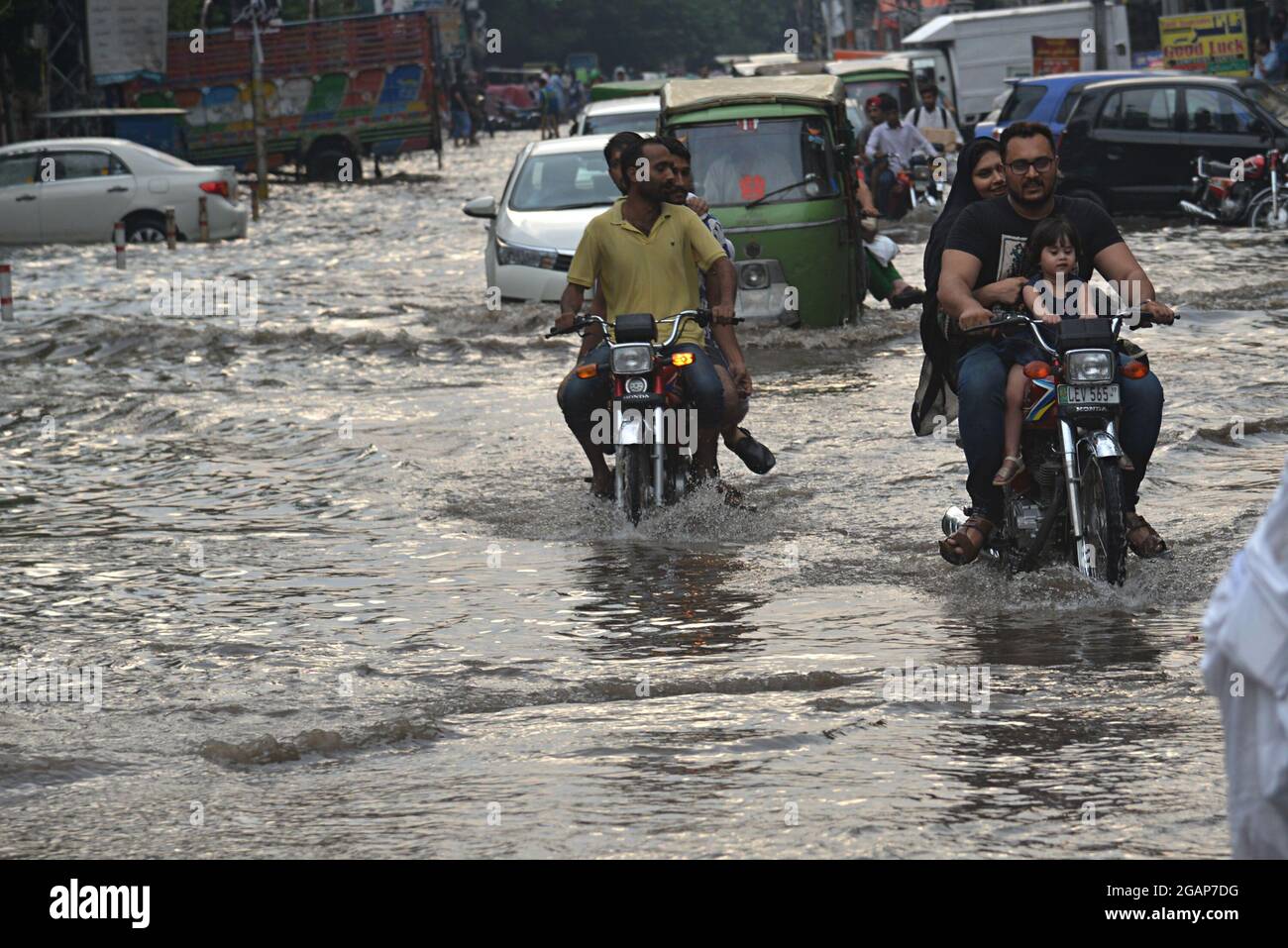 Lahore, Pakistan. 31st July, 2021. Pakistani commuters wade through a ...