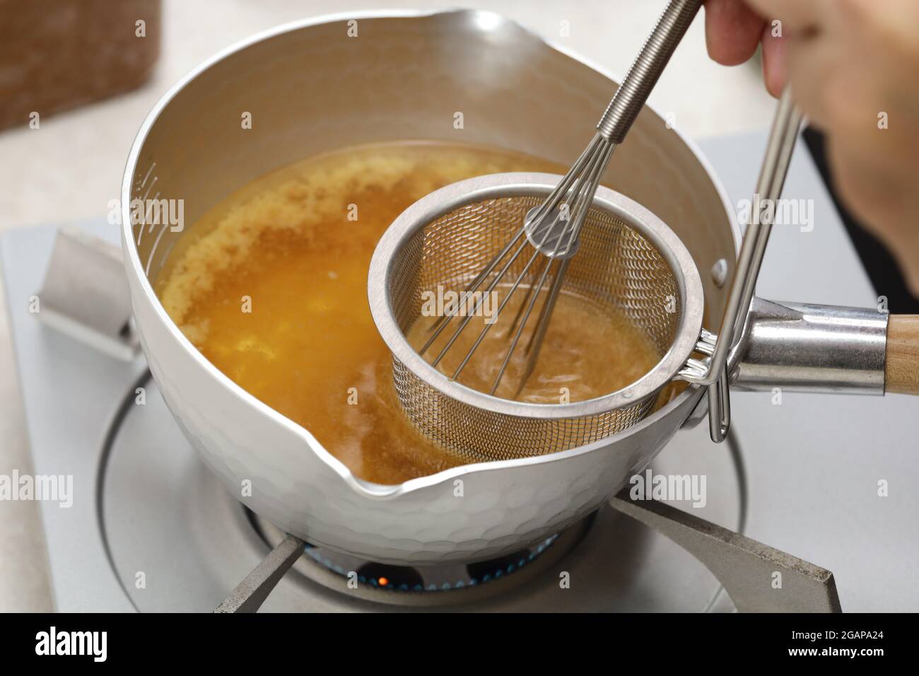 How to make Japanese miso soup.  Dissolve miso with a strainer. Stock Photo