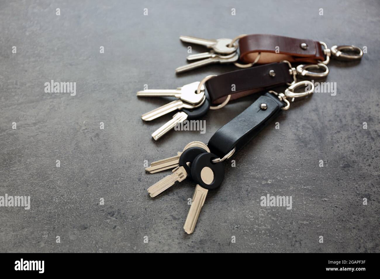Keys attached to leather keychain , on gray background Stock Photo - Alamy
