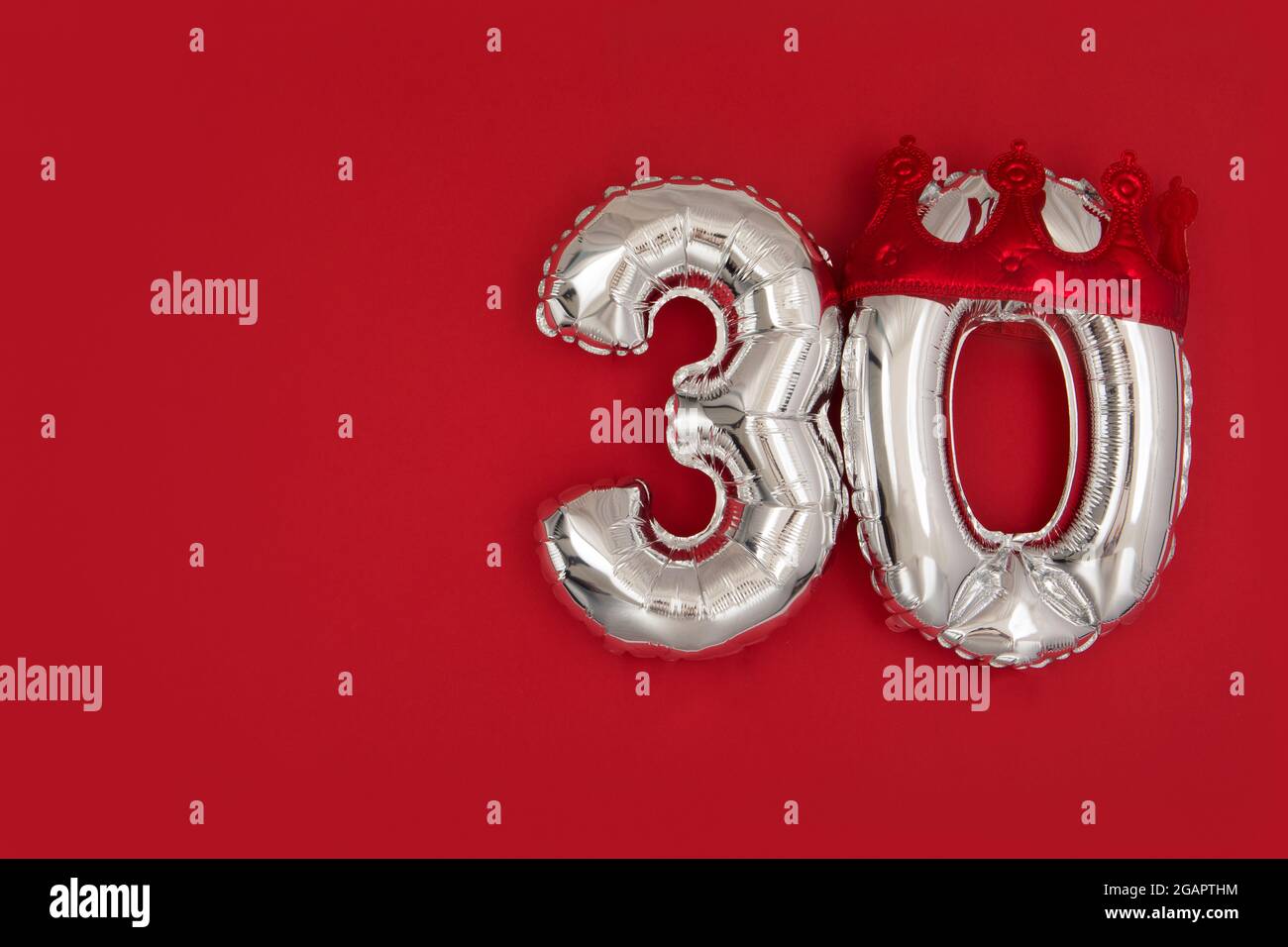 Silver Number Balloons 30 thirty in crown on dark red background. Holiday Party Decoration, 30 postcard concept with top view Stock Photo