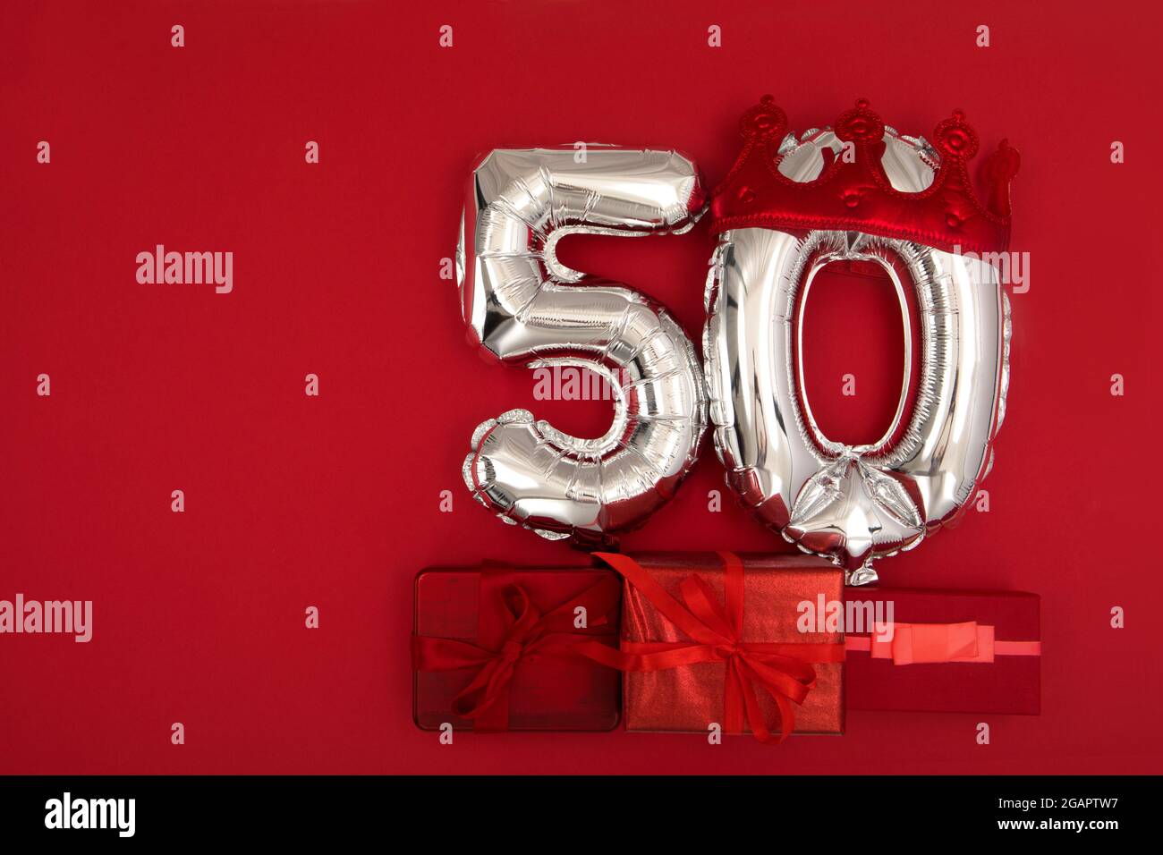 Silver Number Balloons 50 thirty in crown on dark red background. Holiday Party Decoration, 50 postcard concept with top view Stock Photo