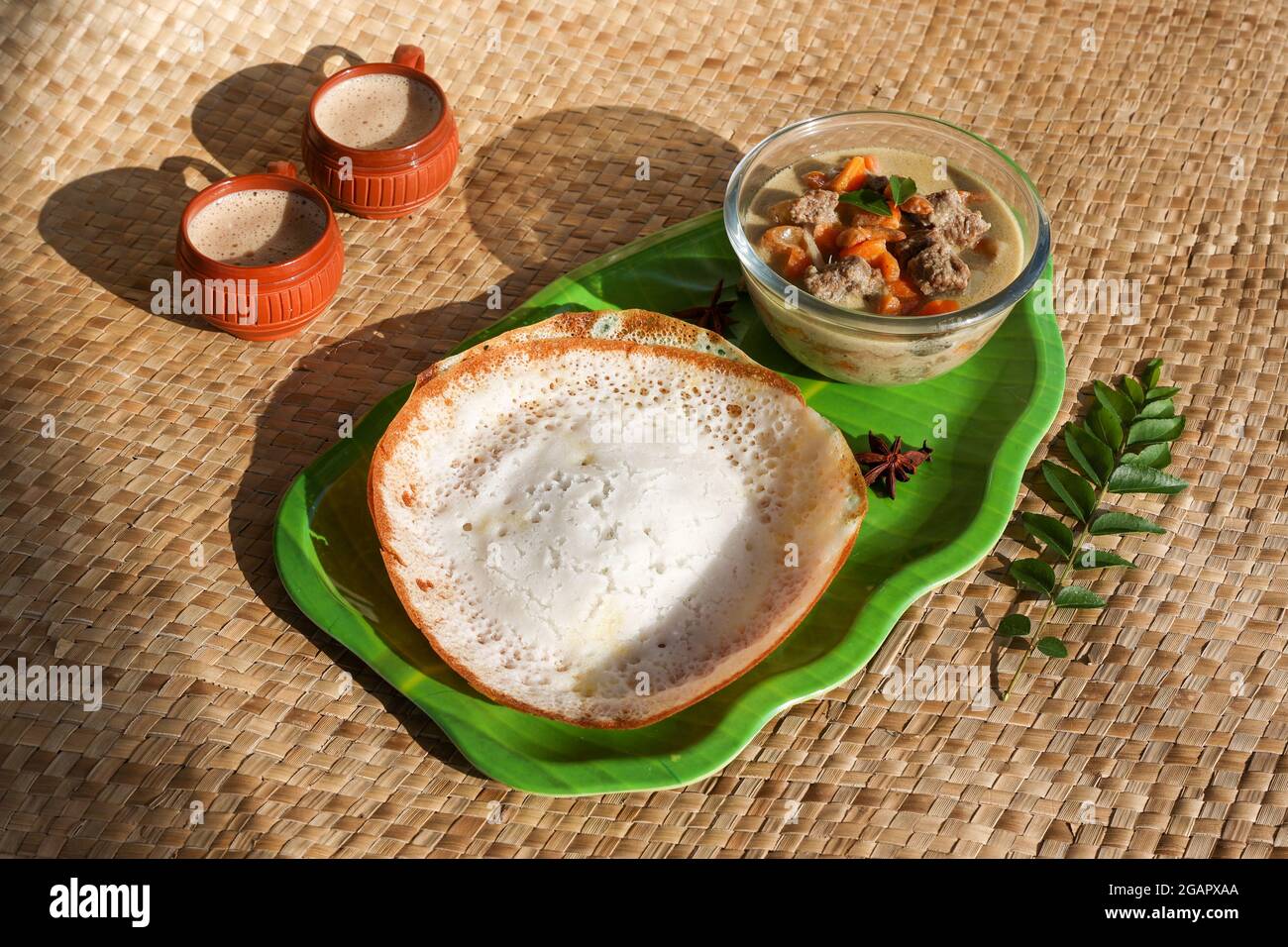 Appam, Hoppers and mutton stew Kerala breakfast food and Indian milk
