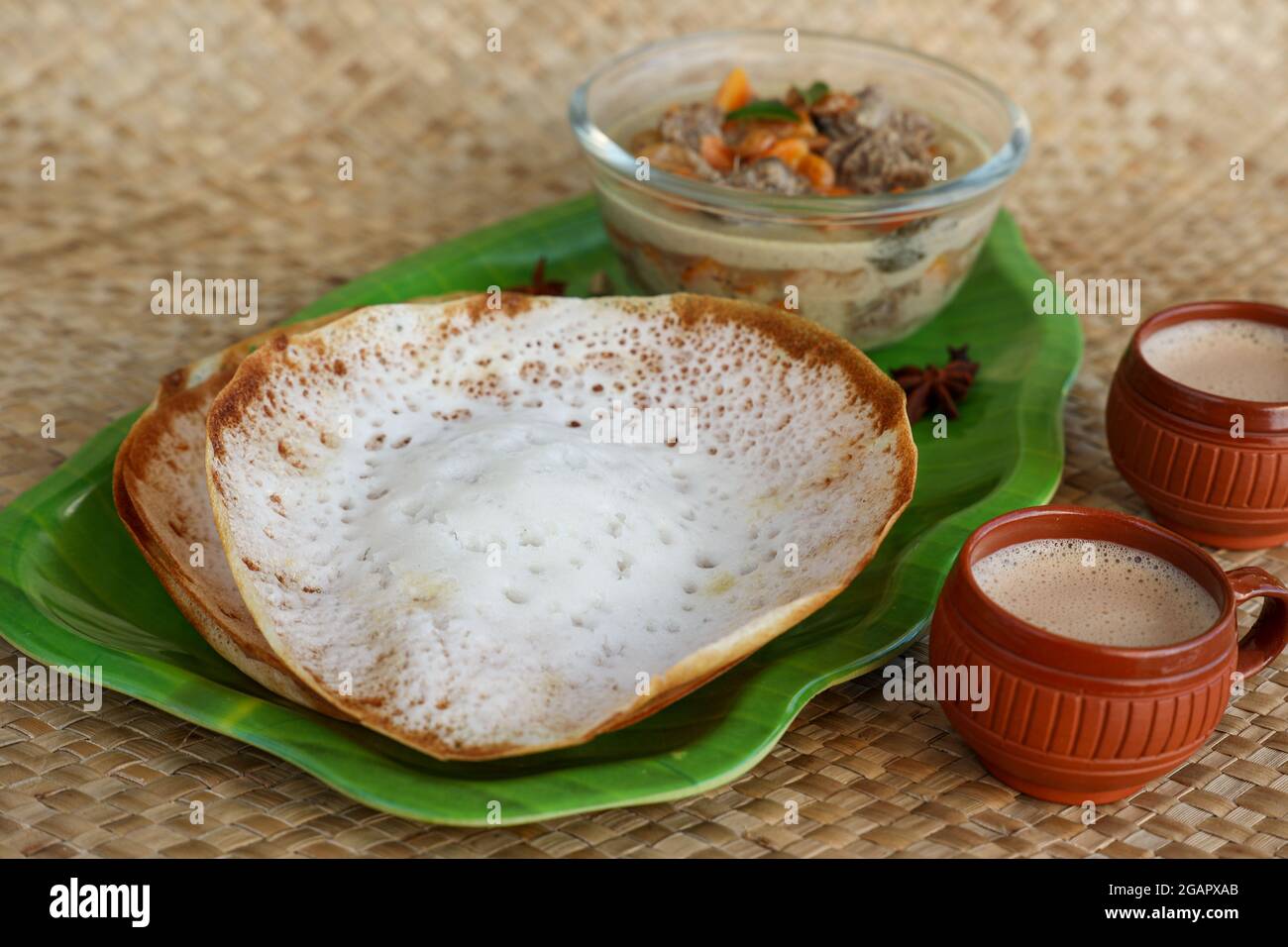 Appam, Hoppers and mutton stew Kerala breakfast food and Indian milk
