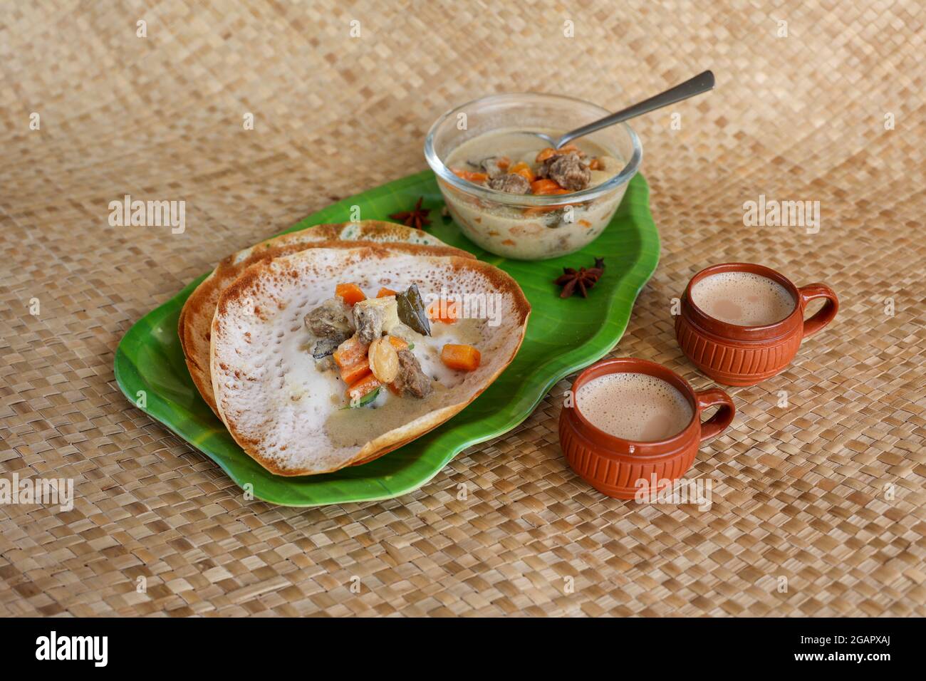 Appam, Hoppers and mutton stew Kerala breakfast food and Indian milk