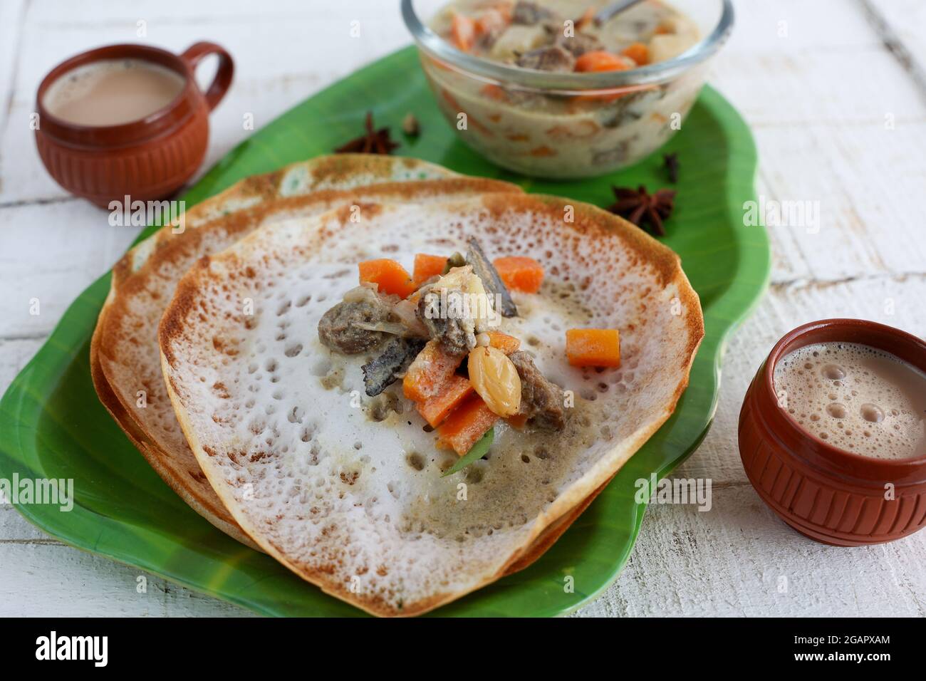 Appam, Hoppers and mutton stew Kerala breakfast food and Indian milk