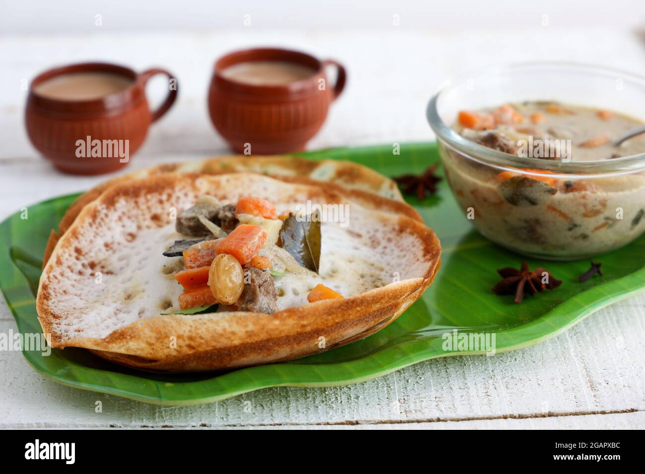 Appam, Hoppers and mutton stew Kerala breakfast food and Indian milk