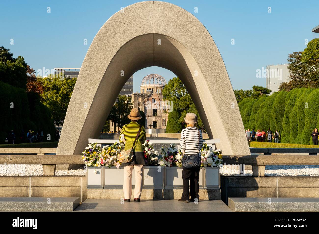 HIROSHIMA, Japan. Hiroshima Peace Memorial Park. 31.10.2019. Two female Japanese tourists contemplating at The Hiroshima Victims Memorial Cenotaph. Stock Photo