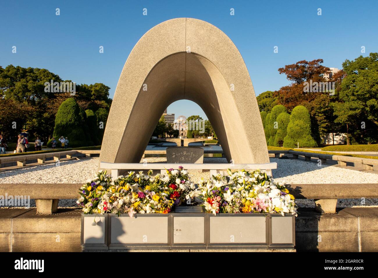 HIROSHIMA, Japan, 31.10.2019. The Hiroshima Victims Memorial Cenotaph with view of Atomic Bomb Dome in Peace Memorial Park, Hiroshima, Japan. Stock Photo
