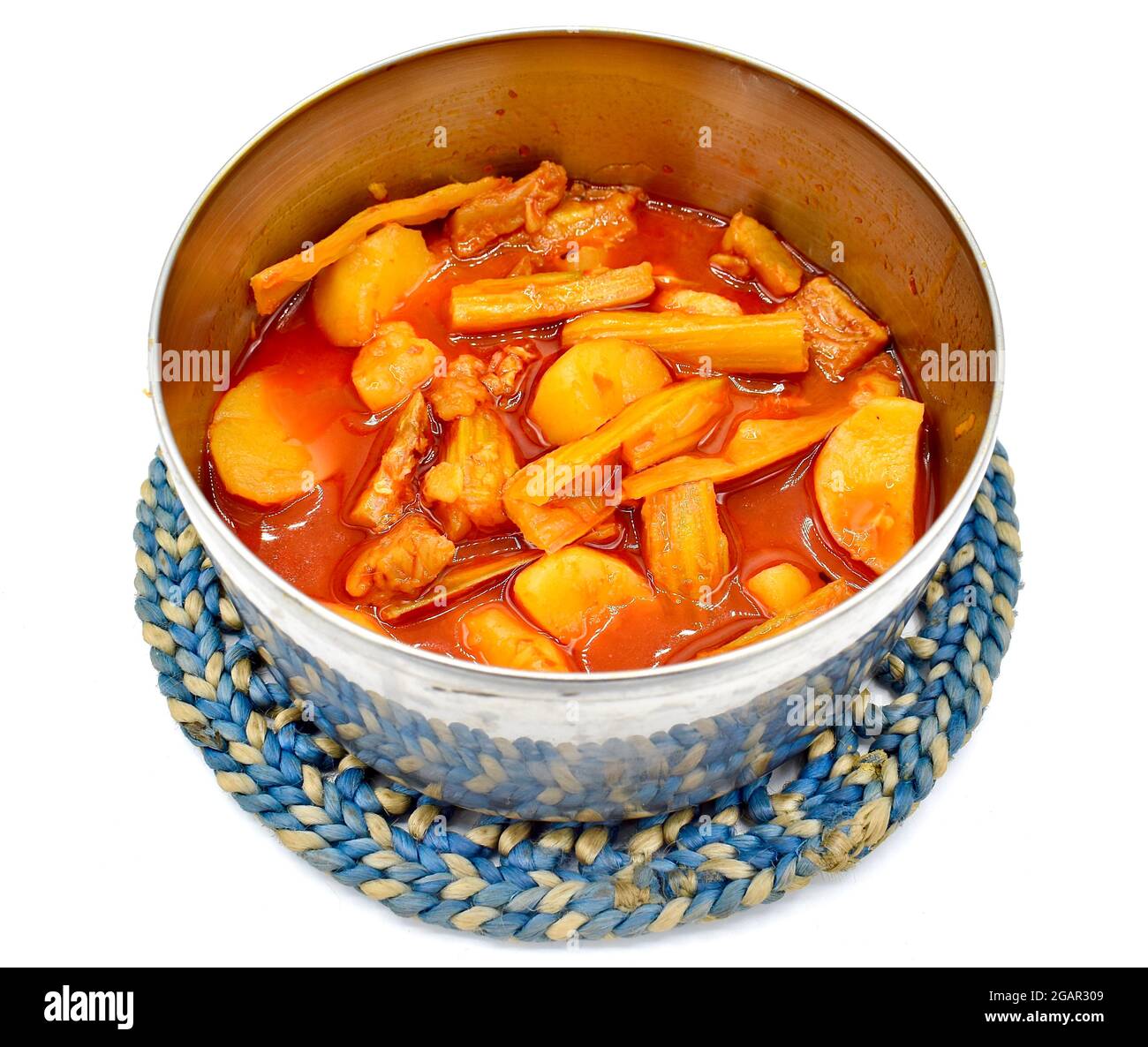 Southeast Asian, Myanmar or Indian traditional chopped drumsticks, dried fishes and potatoes curry with oil in steel dish. Stock Photo