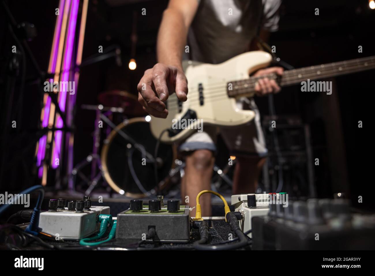 Bass guitar player on a stage with set of distortion effect pedals