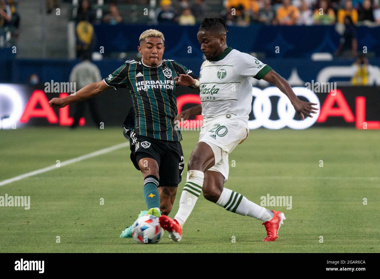 Portland Timbers midfielder George Fochive (20) and Los Angeles Galaxy defender Julian Araujo (2) fight for possession during a MLS match, Friday, July 30, 2021, in Los Angeles, CA. The Galaxy defeated the Timbers 4-1. (Jon Endow/Image of Sport via AP) Stock Photo