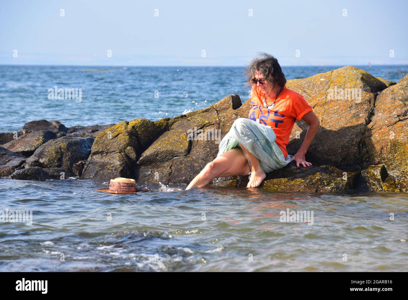 Straw hat falls off rock into the sea, North Berwick, East Lothian