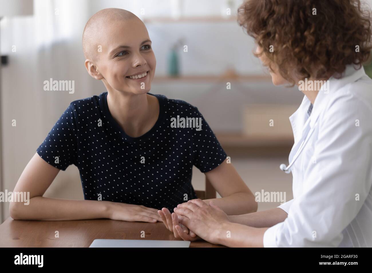 Smiling young cancer patient consulting with doctor. Stock Photo
