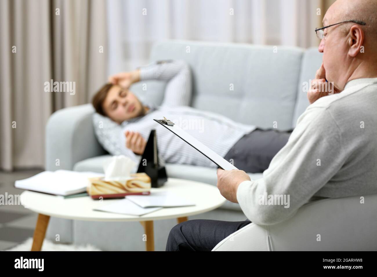 Young man lying on sofa on reception at psychologist Stock Photo - Alamy