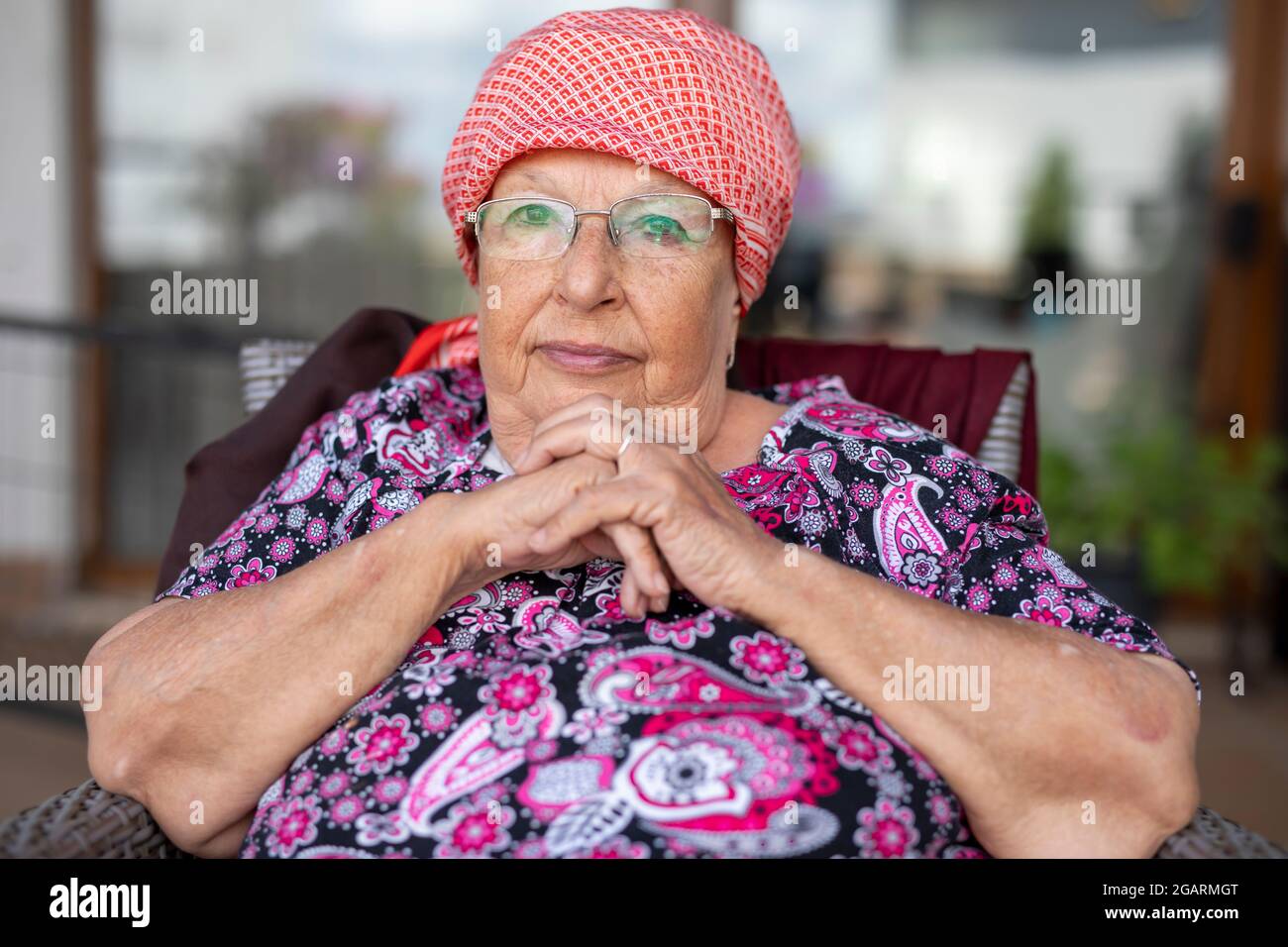 Portrait of a beautiful old woman with gray hair and glasses Stock Photo