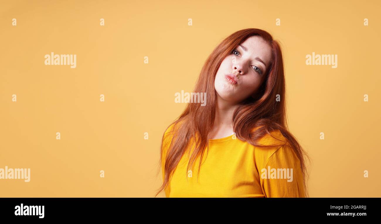 young woman making funny face with pursed lips for kiss or duckf Stock Photo