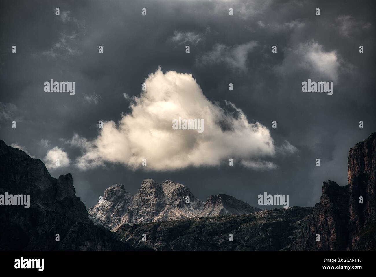 White cloud illuminated by the sun over the top of the mountains during the storm Stock Photo