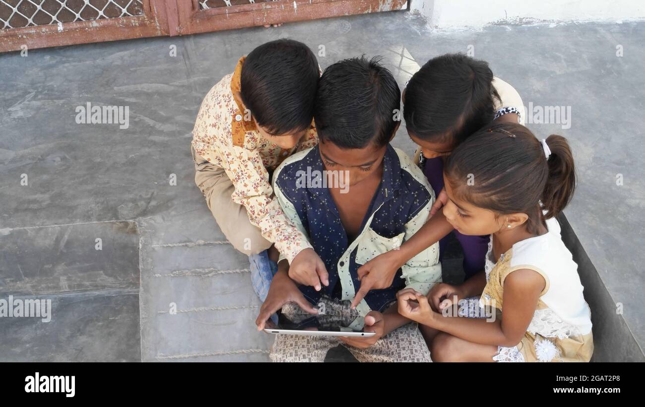 A group of Indian children playing with a tablet Stock Photo