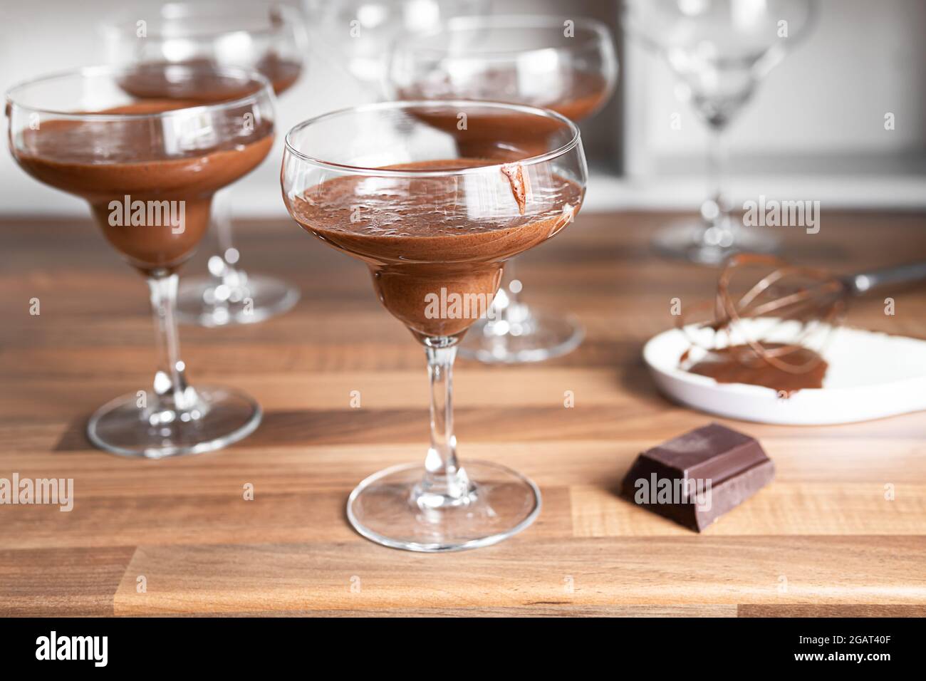 Bowls with chocolate mousse and a piece of dark chocolate on the countertop of a Scandinavian-style kitchen Stock Photo