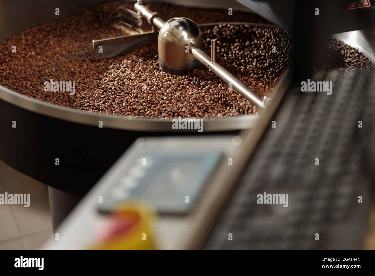Coffee processing. Roastery, roasting machine and fresh beans Stock ...
