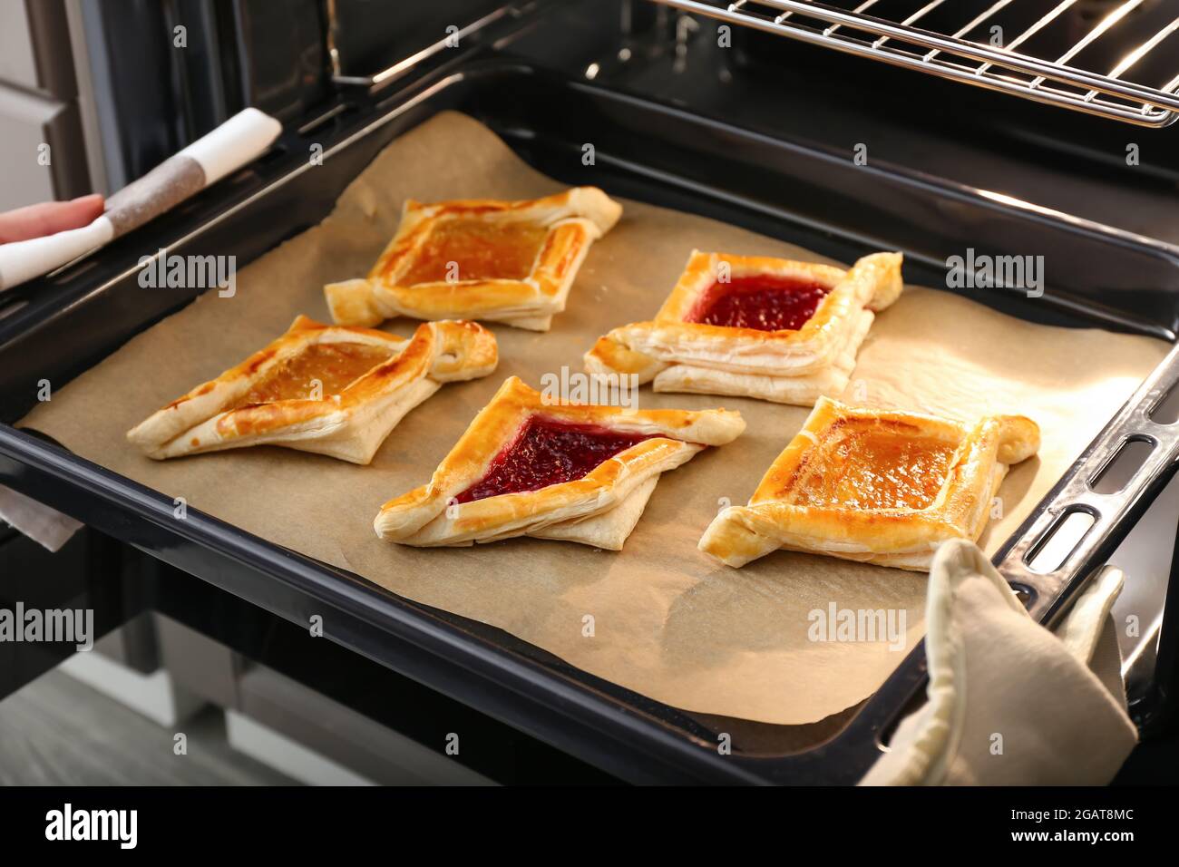 Woman taking out of oven baking tray with Danish pastry, closeup Stock  Photo - Alamy