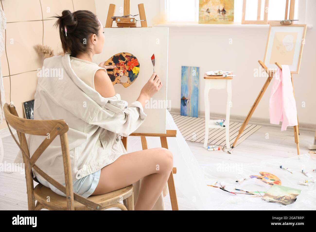 Young female artist painting in workshop Stock Photo - Alamy