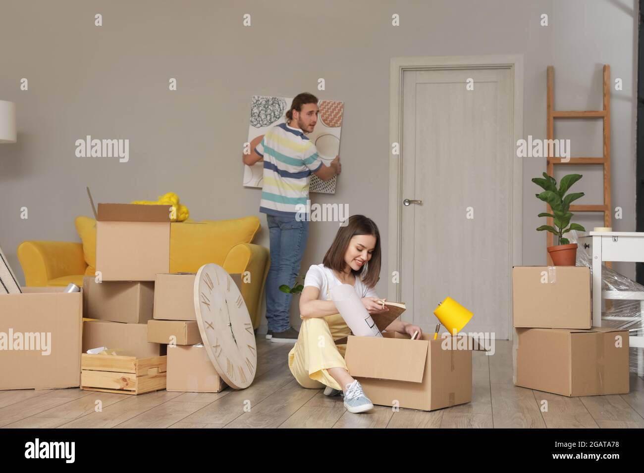 Young couple with cardboard boxes in their new house on moving day ...
