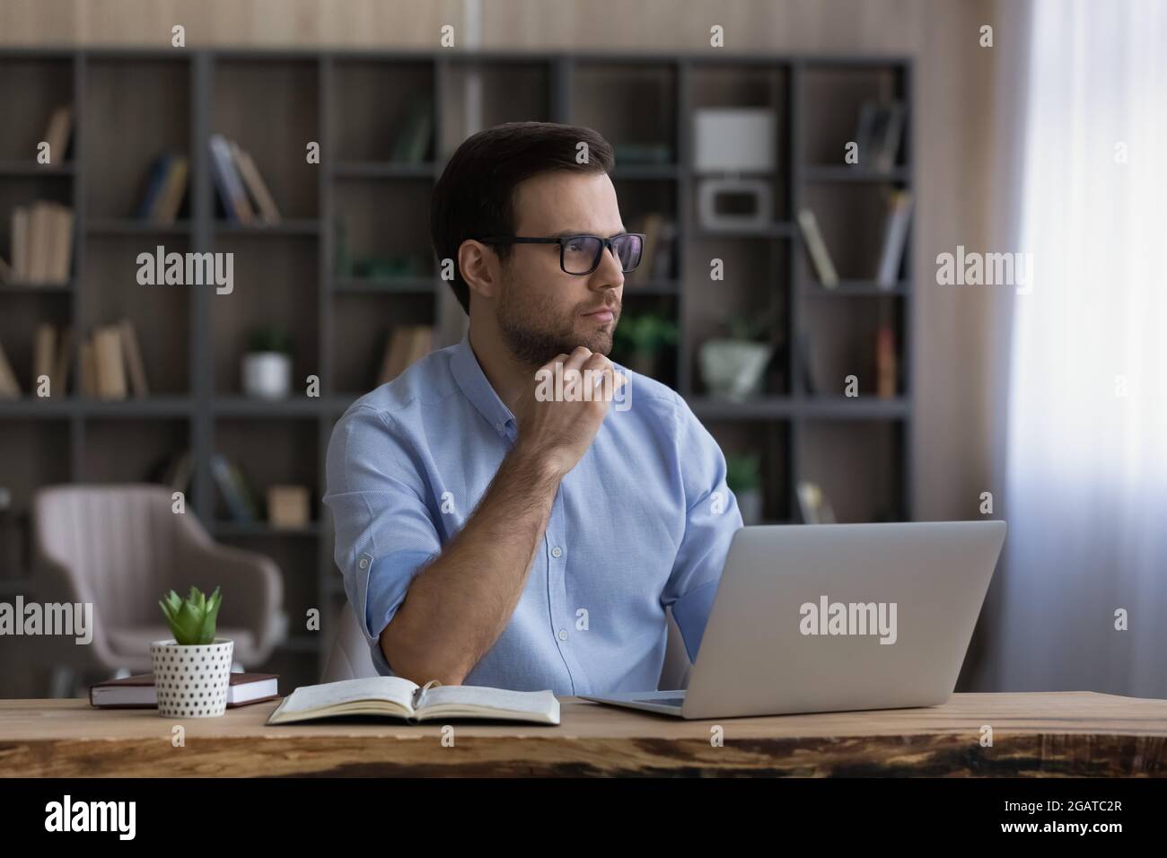 Smart young guy student pass exam using laptop think ponder Stock Photo
