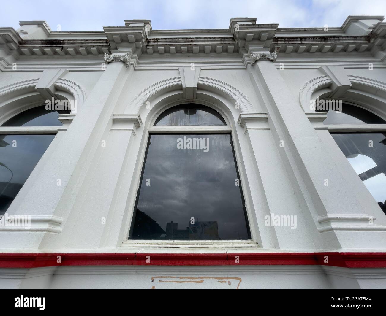 A low angle shot of a building with arched windows and white walls ...