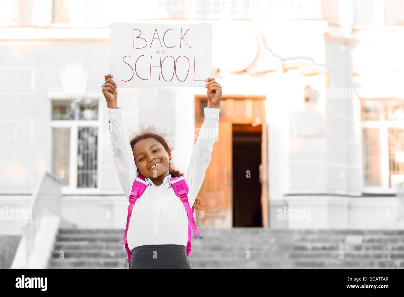 Cute African-American girl holding poster with text BACK TO SCHOOL ...
