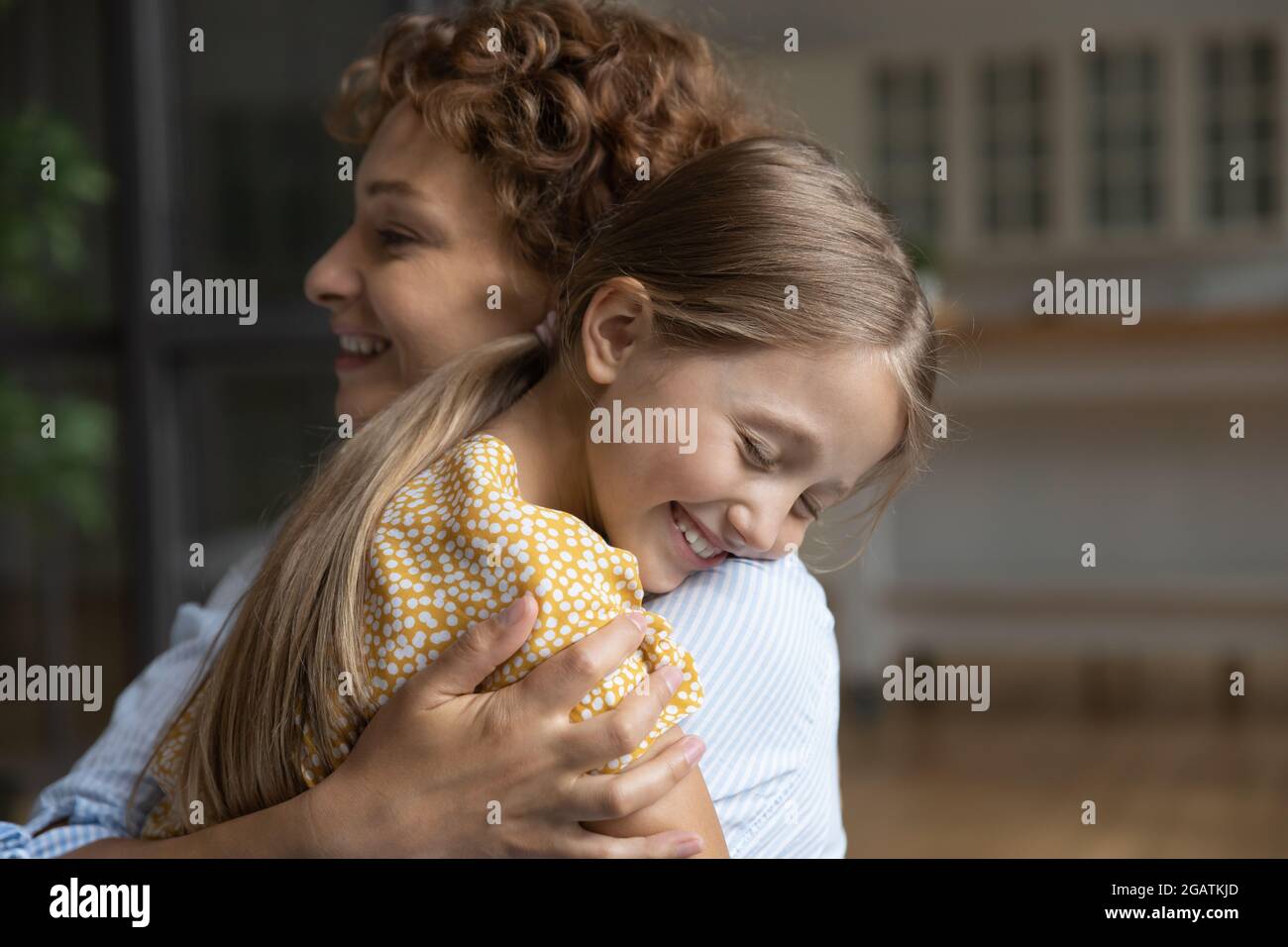 Close up smiling adorable little daughter and loving mother hugging Stock Photo