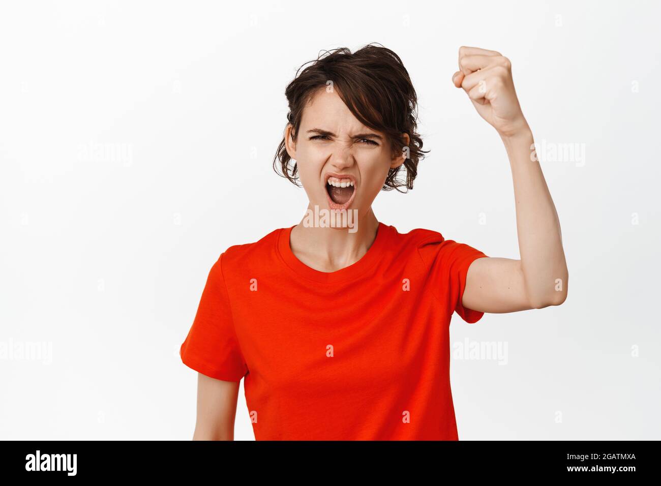 Go team. Young woman shouting and raising clenched fist, fighting for