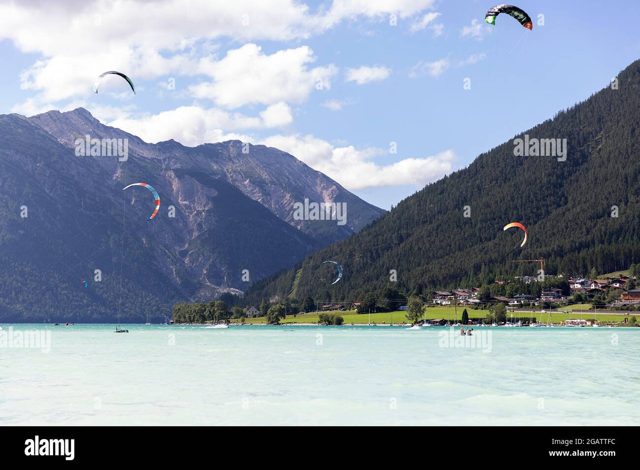 kite surfing on mountain lake in summer alpine landscape. Achensee, Achen Lake, Austria, Tyrol Stock Photo