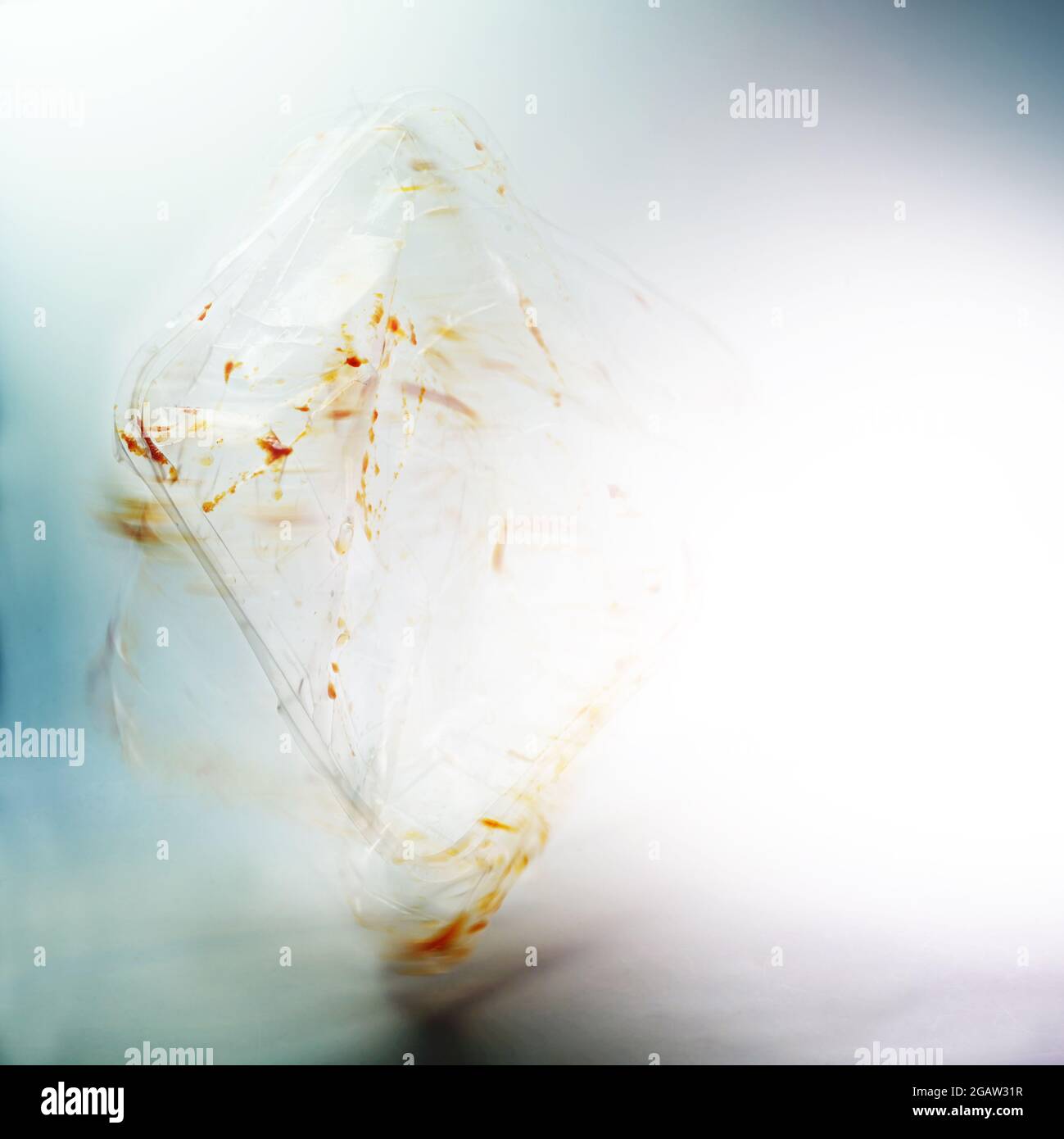 abstract image of a transparent plastic packaging from convenience food in motion blur against a light background, waste of the abundance and throwawa Stock Photo