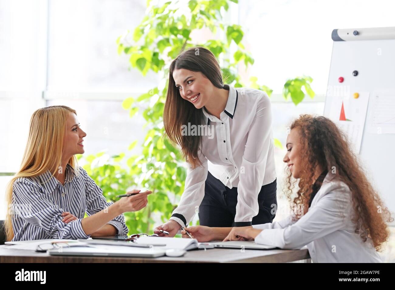 Three young businesswomen at the meeting in a conference room Stock ...