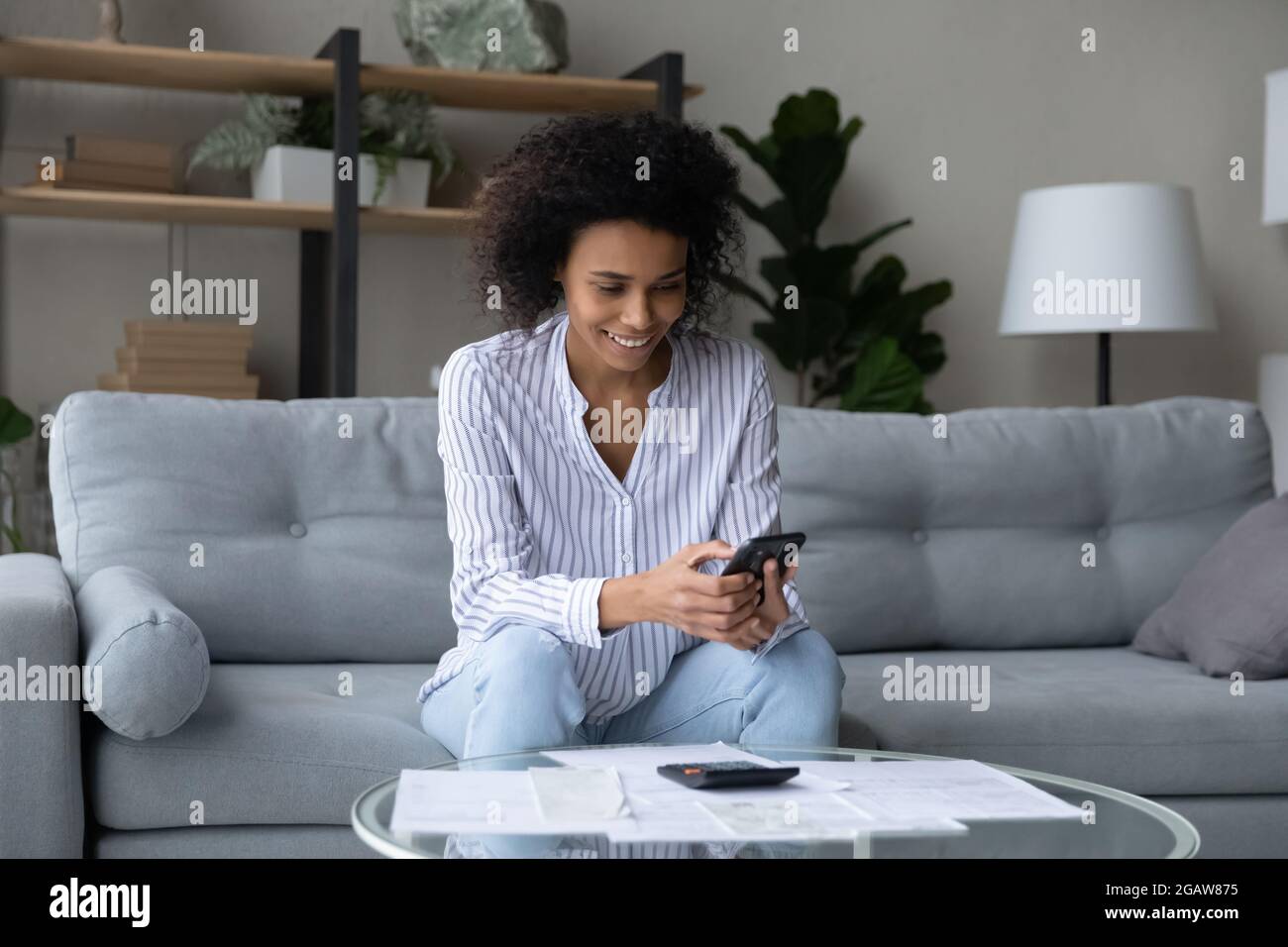 Smiling African American woman manage budget at home Stock Photo