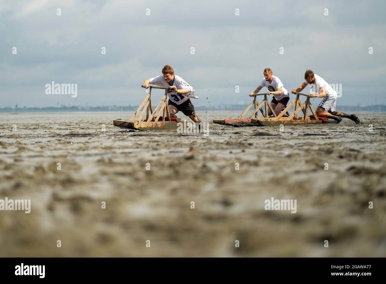 Nordseebad Dangast, Germany. 01st Aug, 2021. Three men ride their mud