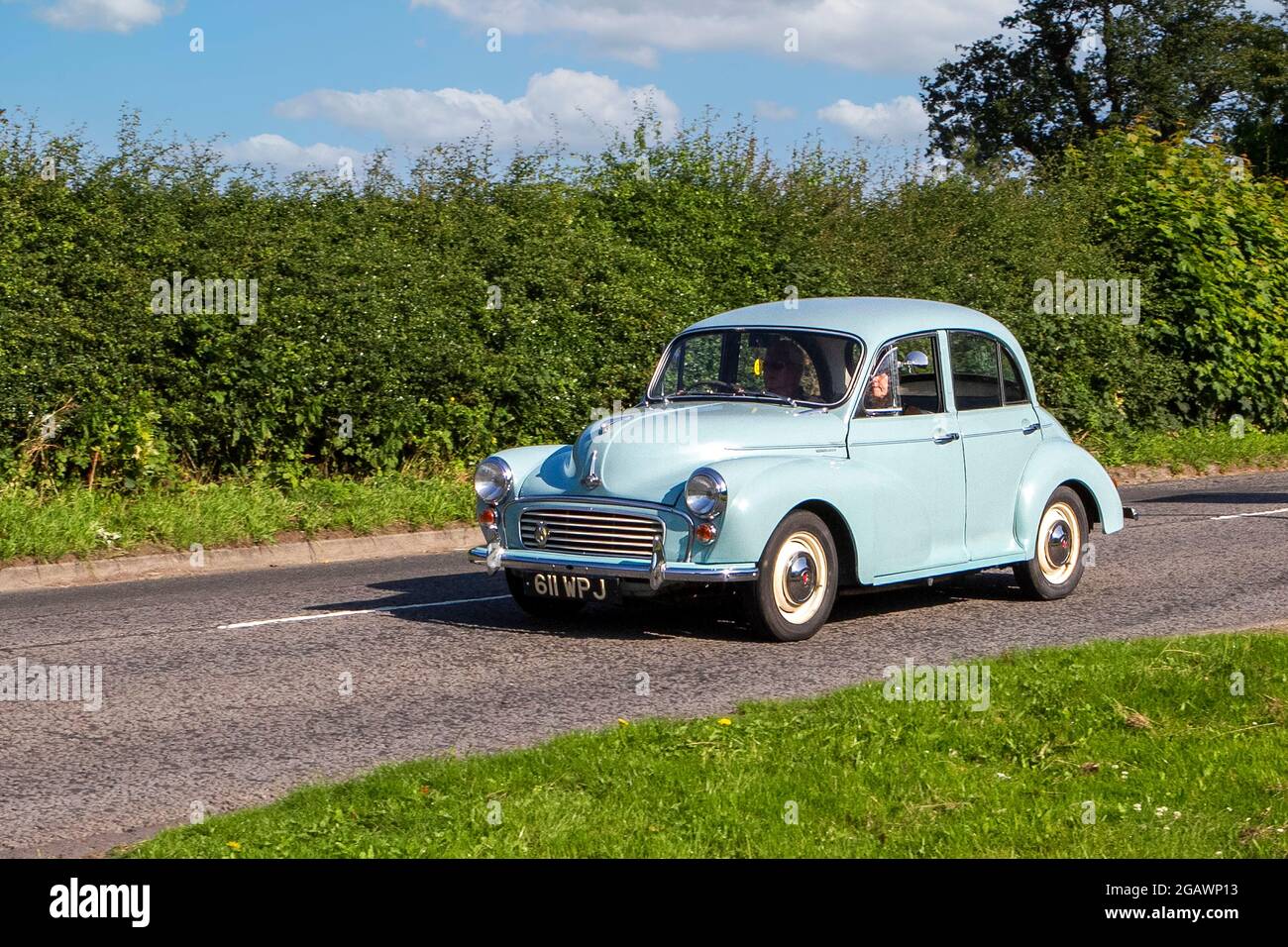 A 1962 60s Morris Minor 1000 Blue Car classic vintage car arriving at the Capesthorne Hall classic car show. Stock Photo