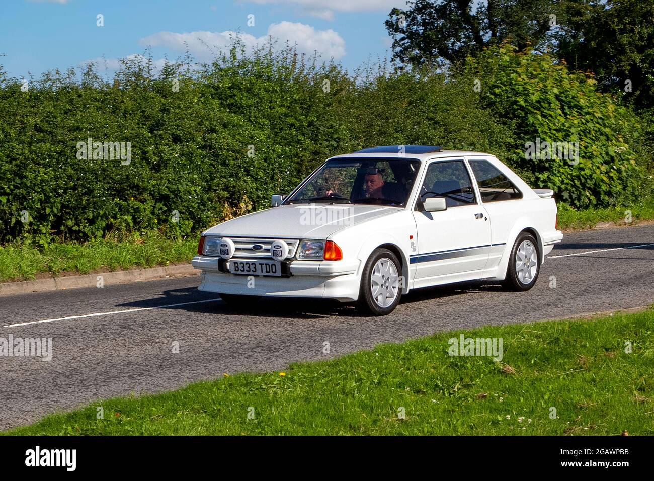 A 1985 80s Ford Escort Rs Turbo White Car Hatchback classic vintage car arriving at the Capesthorne Hall classic car show. Stock Photo